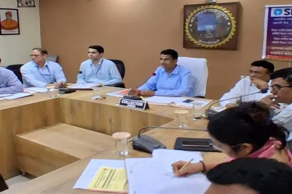 कलेक्ट्रेट के सभाकक्ष में मेज के चारों ओर बैठे अधिकारी और बैंक प्रतिनिधि बैठक करते हुए