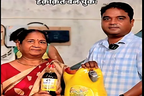 एक पुरुष और एक महिला हाथ में सरसों तेल की बोतल और पीले रंग का टीन/कैन पकड़े खड़े हैं, पीछे दीवार और कुछ सामान दिख रहा है।